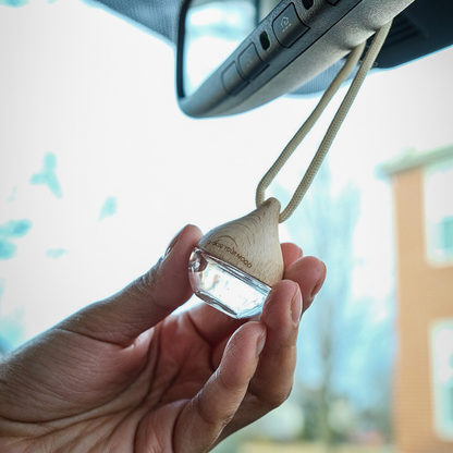 Hand holding a wooden car air freshener 